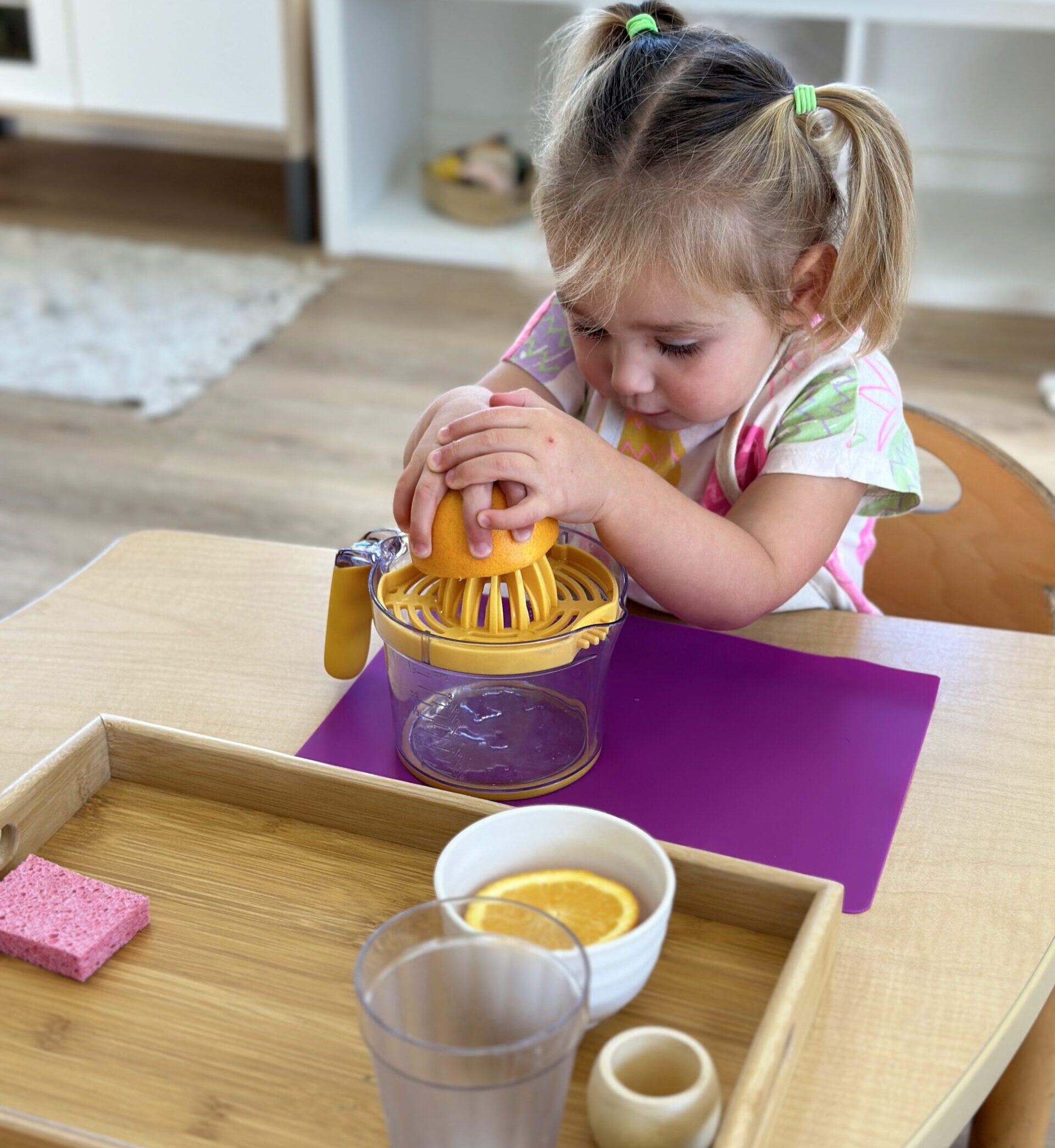 Primary Kindergarten child squeezing orange juice at Shadowridge Montessori School